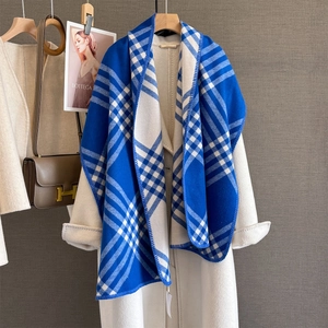 Classic blue and white checkered cashmere-like scarf draped on a minimalist wooden hanger