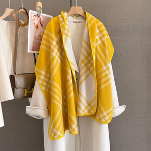 Detail of yellow and white plaid scarf paired with a wool coat and stylish accessories