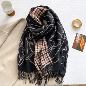 Dettaglio di morbida sciarpa in finto cashmere con motivi di gatti, pied-de-poule e nappe