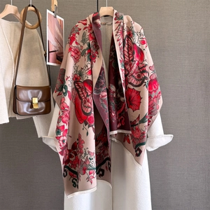 Detailed texture of floral scarf with fringe edges draped over a white wool coat