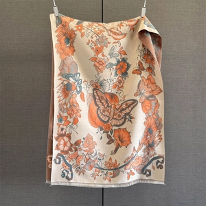 Detail of vintage floral scarf with orange sunflowers and butterflies on beige fabric