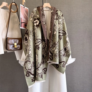 Detail of vintage floral butterfly jacquard shawl with soft fringes and green finish