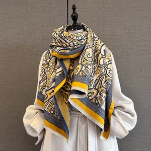 Detail of paisley pashmina shawl with yellow and navy patterns and white fringe trim