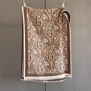 Detailed view of beige paisley cashmere scarf with fringe edges and vintage pattern