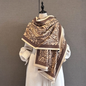 Detail of winter cashmere-feel paisley shawl featuring tassels and warm thick texture
