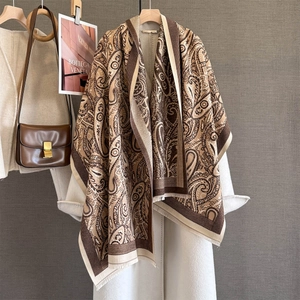 Detail of brown paisley cashmere-like scarf showing exquisite fringe and jacquard texture