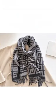 Detail of soft imitation cashmere scarf with grey and black Greek key patterns and tassels