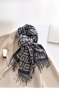 Close-up of jacquard cashmere-feel scarf with geometric patterns and fringe detail
