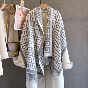 Close-up of geometric jacquard pattern and soft tassel edges on gray cashmere-like scarf