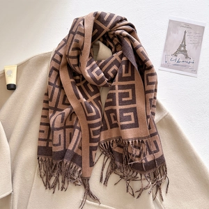 Close-up of thick jacquard scarf with brown geometric patterns and tassel details