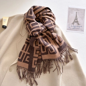 Detailed view of geometric pattern jacquard scarf with soft fringe edges and fabric texture