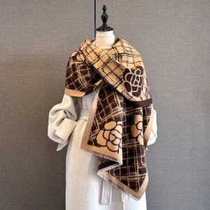 Détail du motif de fleurs de camélia et tissage à carreaux sur une écharpe chaude