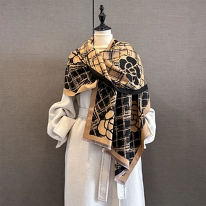 Détail du mélange de cachemire doux avec des rayures camel et un motif de camélia