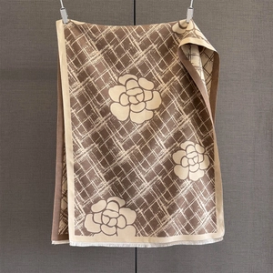 Détail rapproché des franges et de la texture en maille du foulard à fleurs de camélia