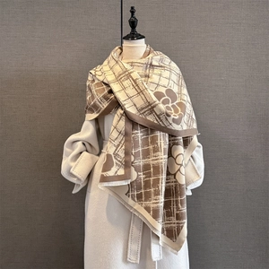 Détail d'une écharpe rayée camélia vintage avec un manteau en laine blanc