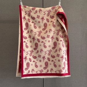 Close-up of winter paisley jacquard scarf with detailed beige and red fringe edges