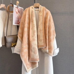 Detail of premium paisley jacquard scarf with intricate floral fringe edge in beige tone