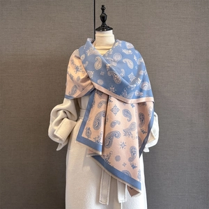 Detail of blue and pink paisley jacquard scarf with thick fringe and soft texture