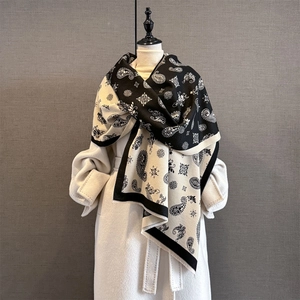 Close-up of ethnic paisley jacquard pattern and soft fringe on black and white shawl