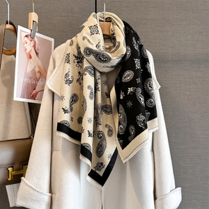 Close-up of black and white paisley jacquard scarf with thick tassel edge detail