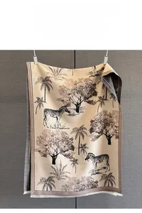 Detail of jacquard scarf with palm tree and zebra patterns and fringe edges