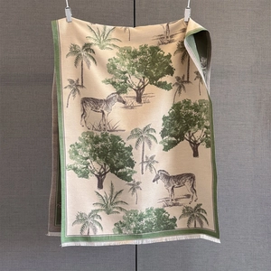 Detail of tropical pattern scarf featuring zebra and palm trees with white tassels