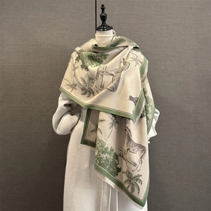 Close-up of zebra print pashmina shawl with tassel trim on a white wool coat