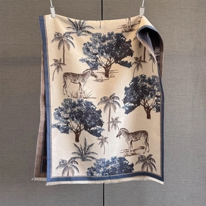Detail of cashmere-like shawl featuring navy safari zebra prints and short white fringes
