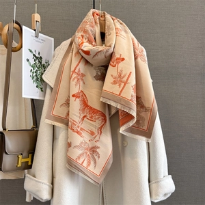 Beige cashmere-feel shawl with orange zebra print and fringe edges on white coat