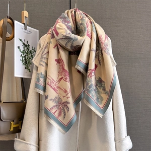 Detail of beige cashmere-feel shawl with red zebra and palm tree prints over white coat