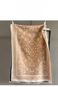 Detailed view of paisley jacquard pattern with frayed tassels on a warm pashmina shawl