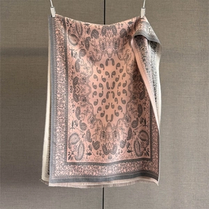 Detail of pink paisley jacquard scarf with intricate floral patterns and fringe edges