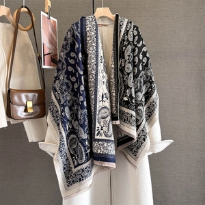 Retro paisley jacquard scarf with contrast colors and fringe, draped on a white coat