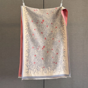 Nahaufnahme der beigen Paschmina-Schal mit rotem Blumenmuster und blauen Fransen