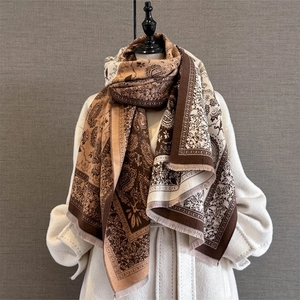 Retro paisley jacquard scarf with tassels in earth tones on white tweed coat