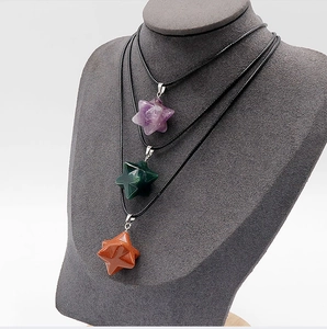 Détails macro des pendentifs Merkaba en améthyste et aventurine sur présentoir velours