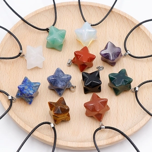 Vielfalt an 24mm Merkaba Naturstein-Anhängern mit Kordeln auf Holztablett