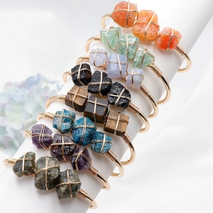 Set mit 8 Boho-Armbändern aus goldumwickelten Natursteinen auf einem Displayständer