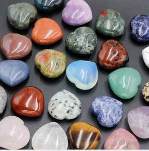 Macro view of polished heart-shaped natural crystals including rose quartz and tiger eye