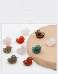Polished natural crystal ducklings in tiger eye and rose quartz on a wooden tray