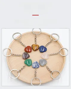 Macro detail of eight heart-shaped natural crystal keychains on a wooden tray display