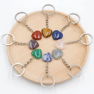 8-piece set of heart-shaped natural stone keychains on a wooden tray with diverse crystals