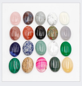 Flat lay of 20 oval gemstone cabochons including rose quartz and tiger eye stones