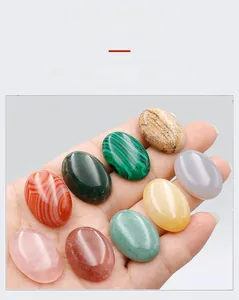 Detailed view of natural oval crystal gemstones held by hand showcasing textures