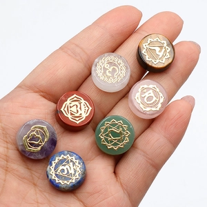 Juego de siete piedras de chakra de cristales naturales con símbolos dorados en mano