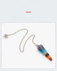 Macro detail of hexagonal 7-chakra natural crystal pendulum with silver chain and sphere