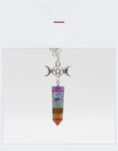 Detailed view of triple moon goddess charm on a seven-layer chakra crystal point pendant