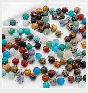 Assorted natural gemstone pumpkin charms with silver loops on a white background