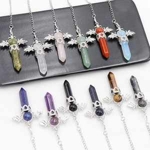 Natural gemstone hexagonal crystal pendants with silver angel wings on display