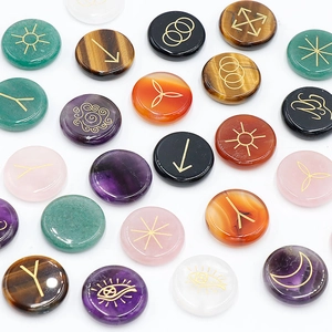 Polished natural crystal rune stones with gold engraved symbols on white background